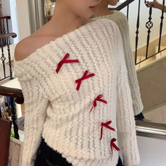 Jersey de punto de manga larga con hombros descubiertos y lazo rojo navideño