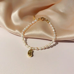 Collar con colgante de frijol dorado con cuentas de perla natural