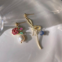 Ohrringe mit rosa Rosenblüte und goldener Schleife