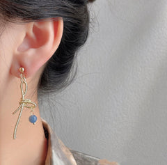 Ohrringe mit rosa Rosenblüte und goldener Schleife