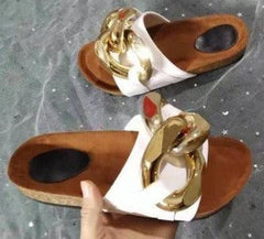 Sandalias tipo mules con punta abierta y suela plana y cadena de metal
